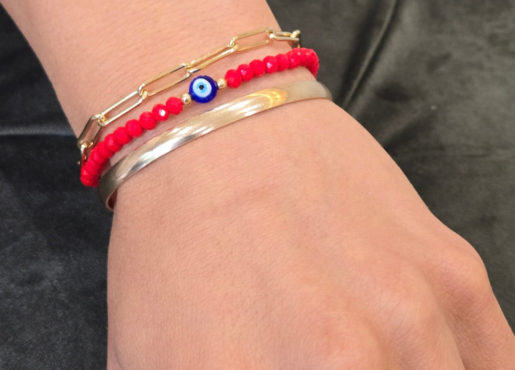 Close-up of a wrist wearing multiple bracelets on a dark background