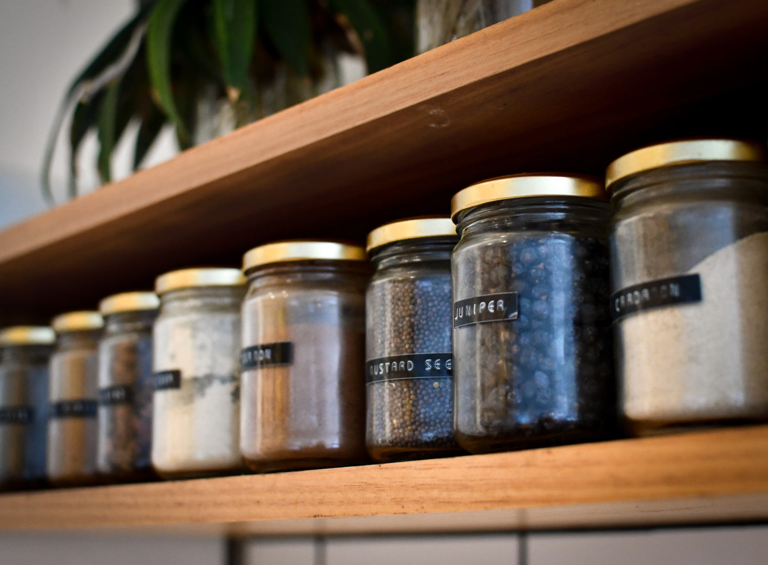 Picture of jars of homemade food like jam, chutneys, with a cloth wrapped top. 