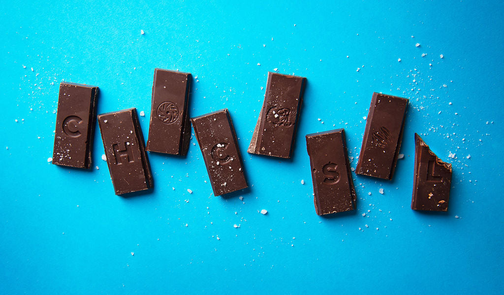 Picture of 3 bars of chocolate against a white background. Some of the chocolate is broken up. 