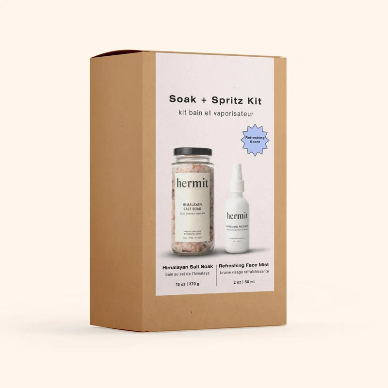 Image contains a brown paper box with a jar of Hermit bath salts, and a white spritz bottle
