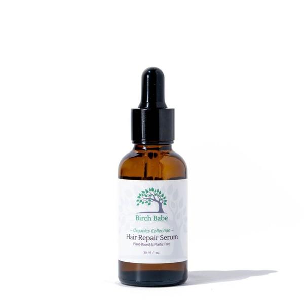 Hair serum in a small amber dropper bottle with a white label.